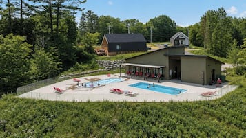 Un resort con piscina, lettini e una zona coperta.