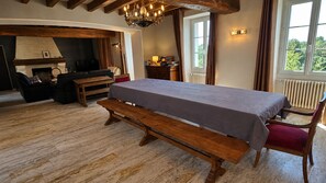 A room with a long table, benches, a fireplace, and a view through a window. - Country house, privacy and nature. (Lesges)
