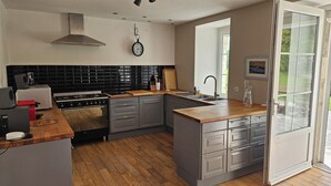 Una cocina moderna con estufa a gas, un lavaplatos y un ventanal grande.