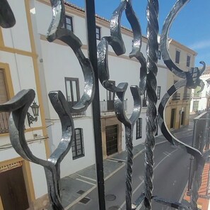 A wrought iron gate with a twisted design, a street view with buildings, and a clear sky. - Tradicional Casa amplia y luminosa con una ubicación excepcional en Ronda (Ronda)