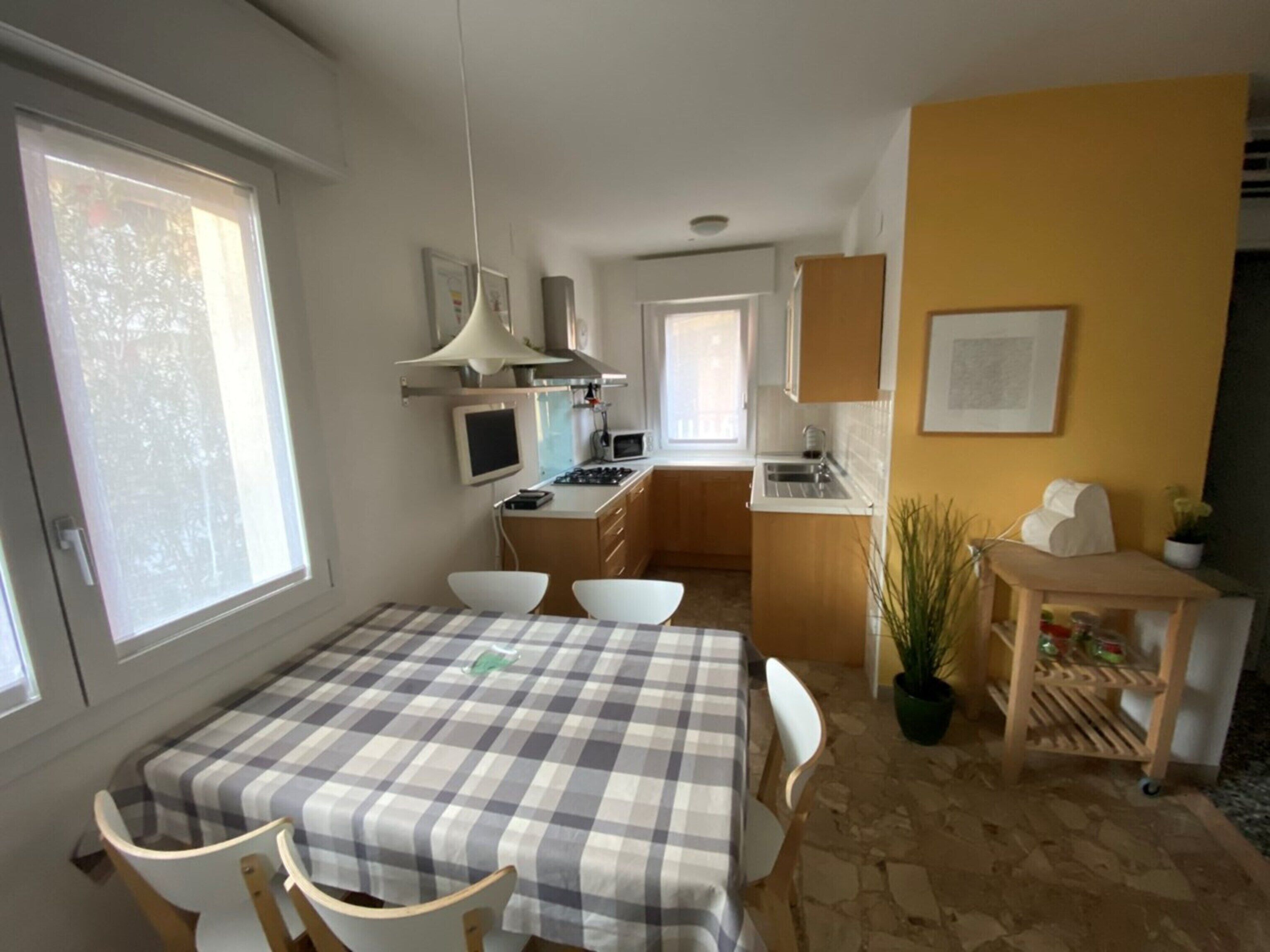 Kompakti keittiö, jossa on ruokailutila, pieni pöytä ja tuolit.