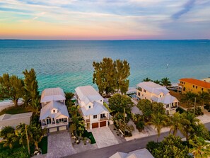 A coastal residential area with houses, a beach, and a view of the ocean. - Beachfront Bliss by Beach Boutique Rentals (Anna Maria)