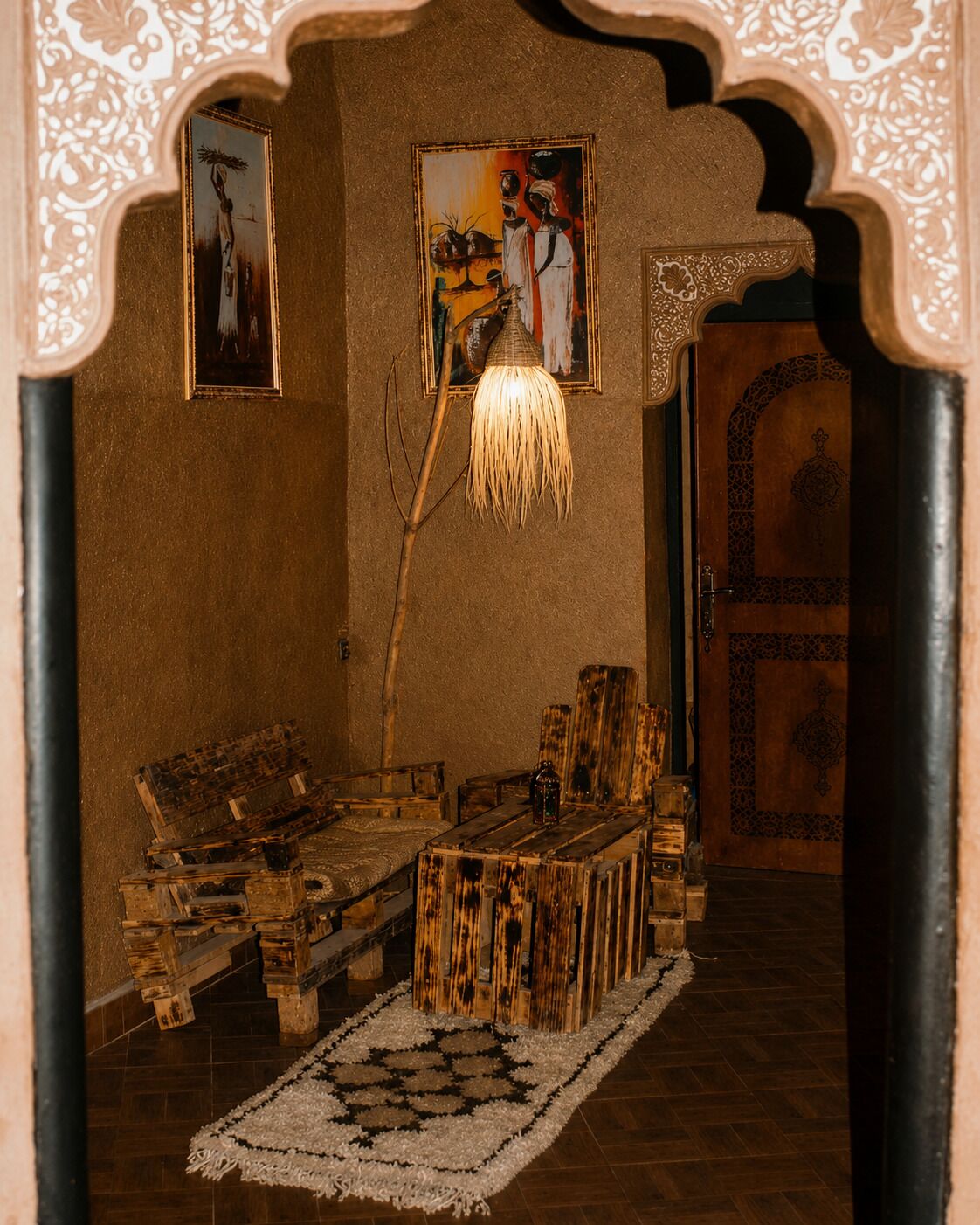 A traditional room with a wooden bench, a hanging light fixture, and a patterned rug.