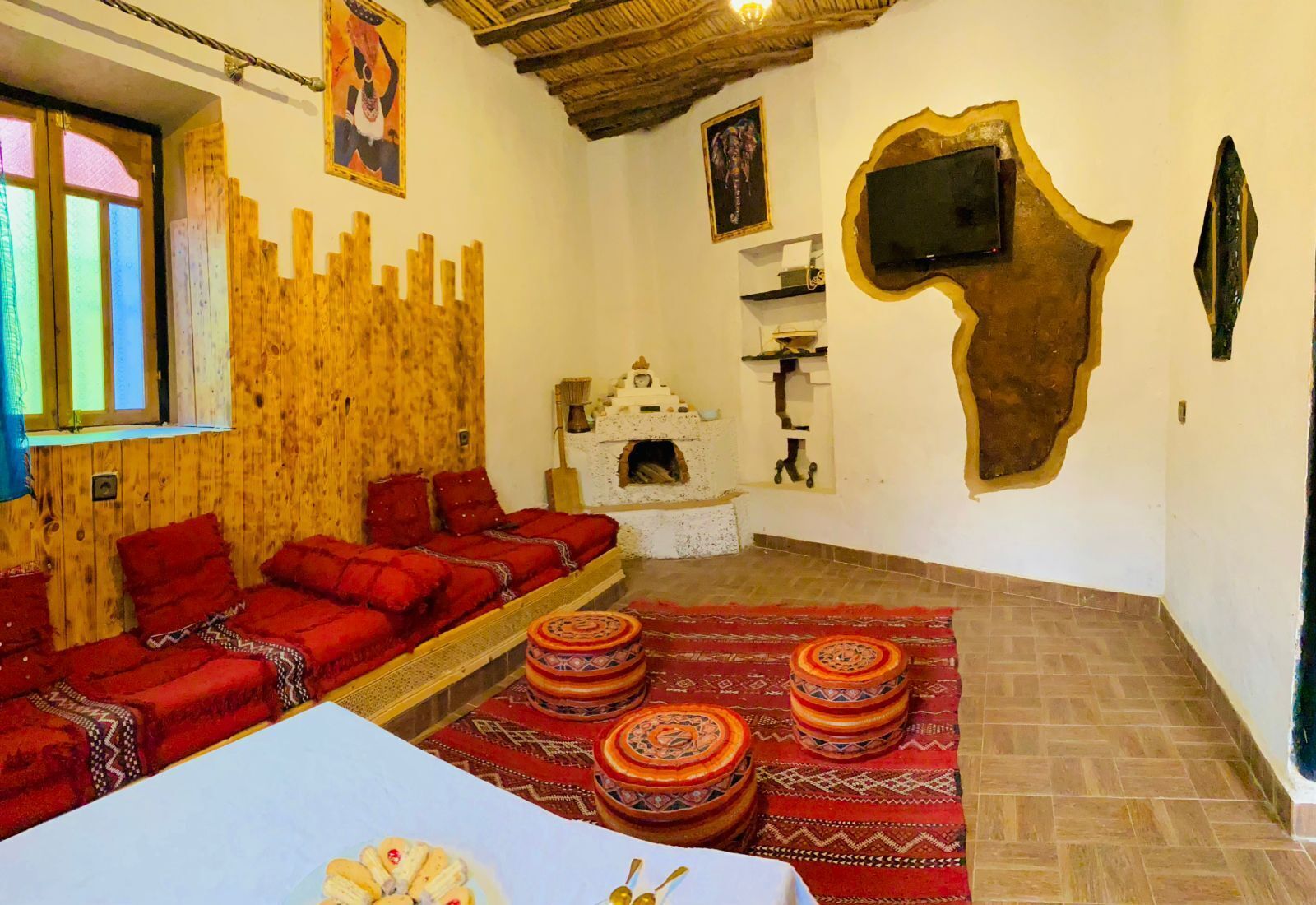Une pièce avec un mur en bois, un canapé, une cheminée, un téléviseur et un tapis à motifs.