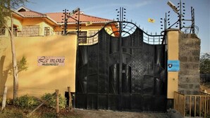 Un cancello con un cartello che riporta la scritta 'La mana maisonettes'.