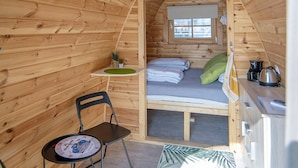 A small, wooden cabin with a loft bed, a table with chairs, and a window. - Unique Water Bubble by the Marina (Almere)