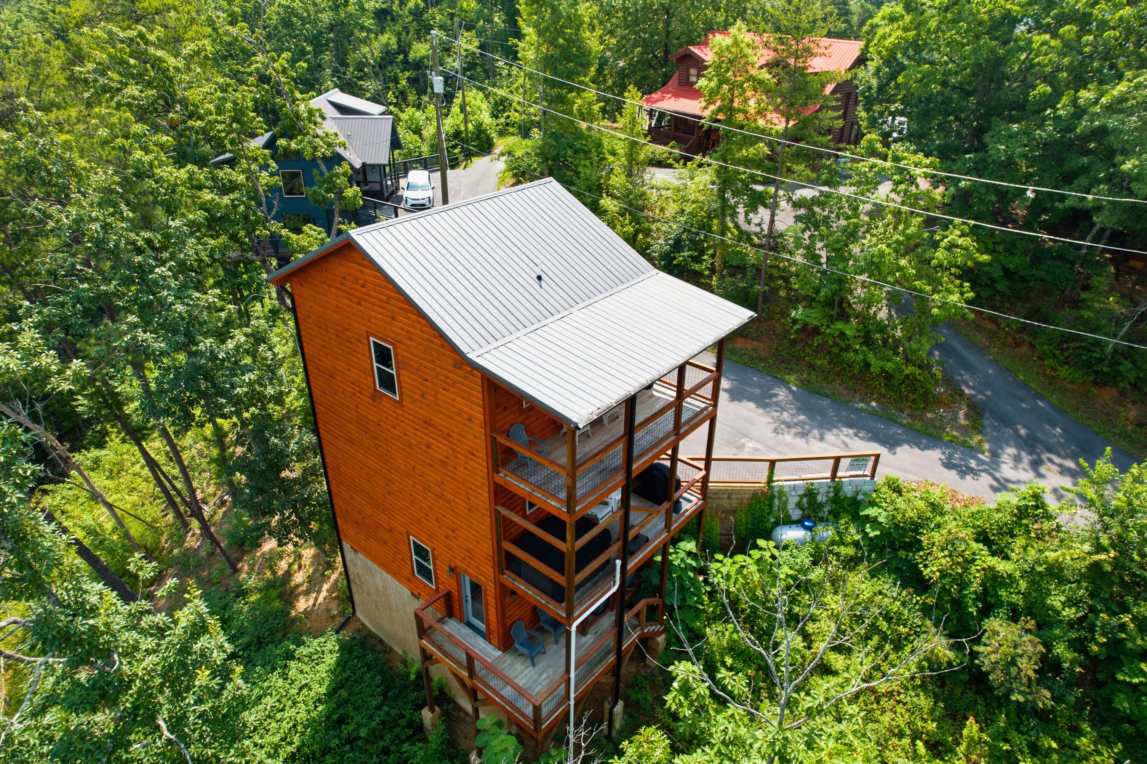 A multi-story wooden building with balconies, surrounded by dense greenery.