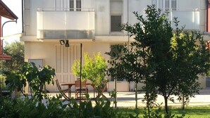 A two-story building with a balcony, outdoor seating, and a well-maintained garden. - Villa Celeste Flexrent - Abissinia Real Estate (Scacciano)
