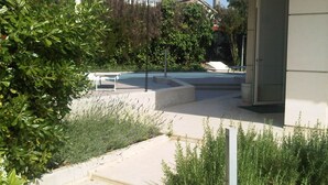 A modern building with a concrete pathway, a door, and greenery. - Villa Celeste Flexrent - Abissinia Real Estate (Scacciano)
