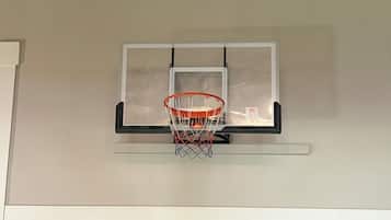 Un panier de basket fixé à un mur, avec un plafond en bois au-dessus.