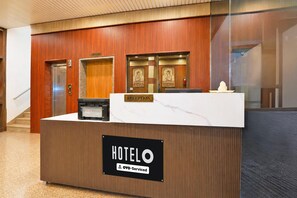 A hotel reception desk with a marble top and a sign indicating it is serviced by OYO. - Classic Super Hotel O Khatu Shyam Temple (Danta Ramgarh)