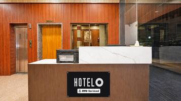 A hotel reception desk with a sign indicating it is serviced by OYO.