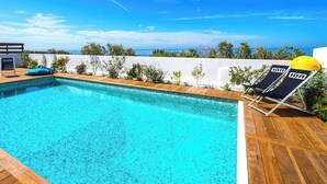 A swimming pool with wooden deck, lounge chairs, and a view of the ocean. - Carro Beach House Villa D'exception Vue Mer (Martigues)