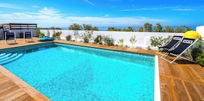A swimming pool with wooden deck, lounge chairs, and a view of the ocean. - Carro Beach House Villa D'exception Vue Mer (Martigues)