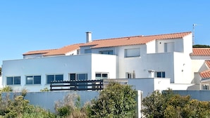 A modern two-story building with a red-tiled roof, white walls, and multiple windows. - Carro Beach House Villa D'exception Vue Mer (Martigues)