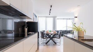 Una cocina moderna con comedor, un sofá y una planta en maceta.