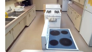 A kitchen with a stove, sink, and refrigerator.