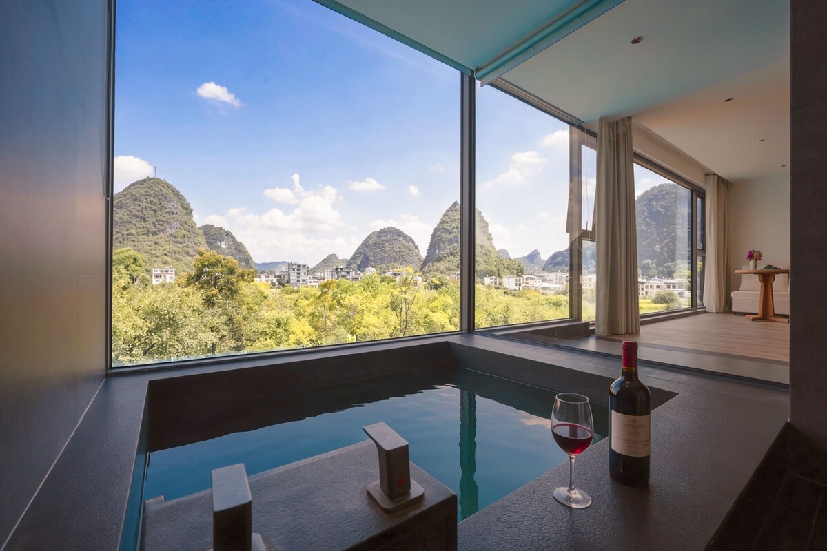 A modern room with a large window overlooking a mountainous landscape.