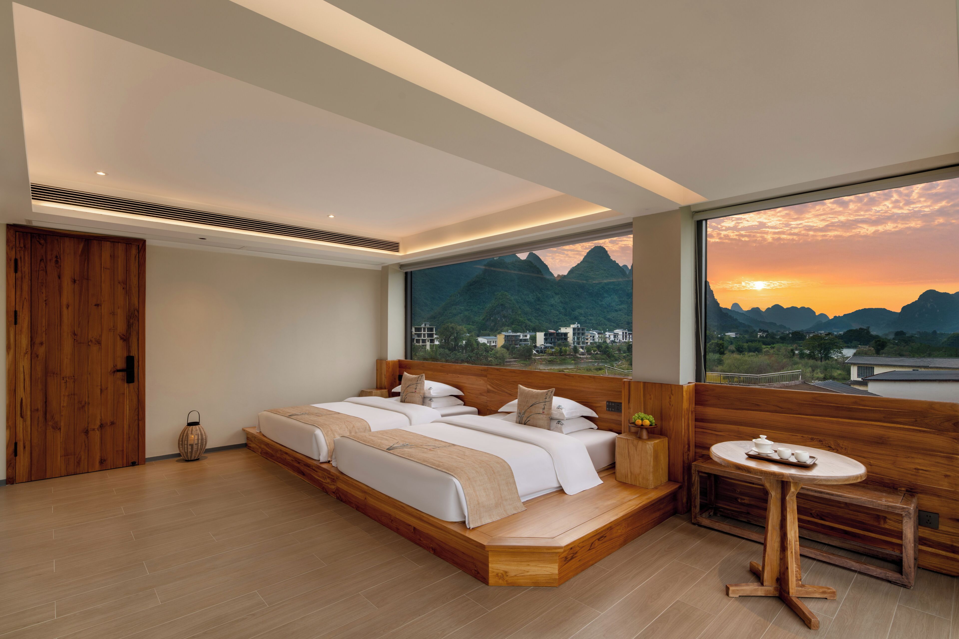 Un dormitorio moderno con una cama grande, una mesita y vistas a las montañas.