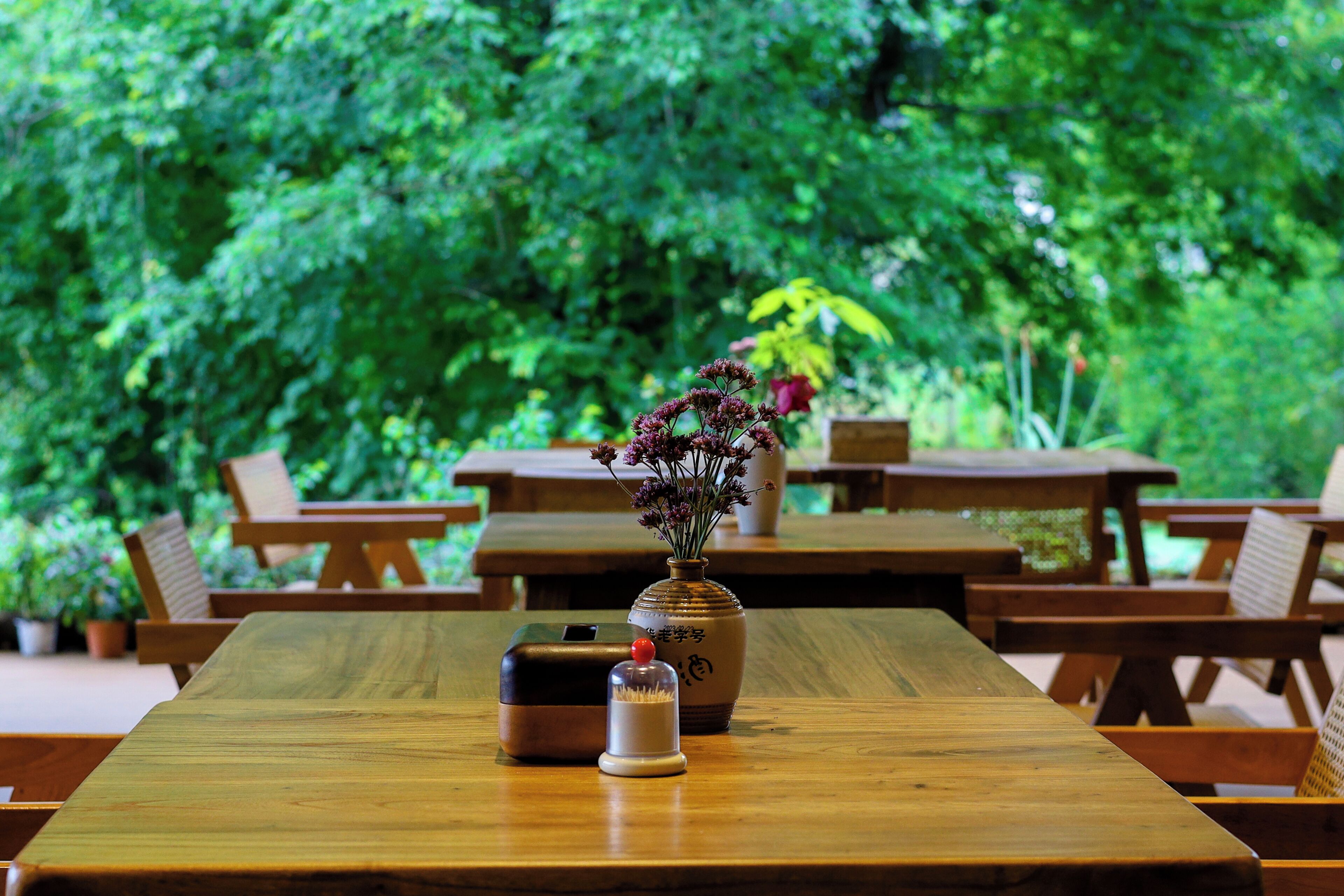 Une table en bois ornée d’un vase de fleurs et d’un petit objet décoratif.
