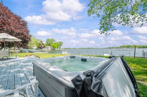 Wake up to sunrise views over Paw Paw Lake at this cozy lakefront cottage with a dock, hot tub, and room for 8.