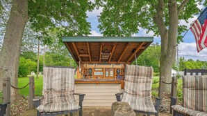 A covered outdoor seating area with striped chairs and a bar counter.