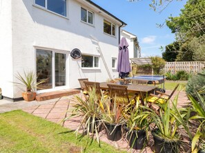 A house with a patio, a basketball hoop, and a ping pong table. - 1 Rosemount Garden Villas (Tenby)