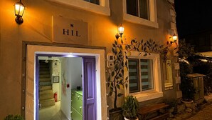 A hotel entrance with a sign reading 'HIL' and a staircase leading to the interior.