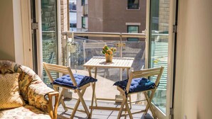 A balcony with a table and chairs, a sofa, and a view of buildings. - Coastal Retreat - Spacious Apartment on Poole Quay (Poole)