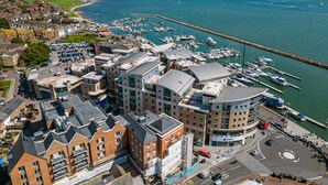 An aerial view of a marina with boats, a roundabout, and surrounding buildings. - Coastal Retreat - Spacious Apartment on Poole Quay (Poole)