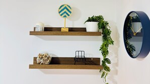 Une pièce avec deux étagères en bois, une horloge et une plante en pot.