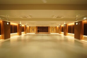 A spacious hotel lobby with a high ceiling, recessed lighting, and a central stage area. - HOTEL SANKET ELITE (Malegaon)