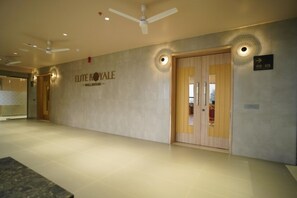 Entrada de hotel con un letrero que dice 'ELITE ROYALE - BALLROOM' y una puerta marcada con los números '410-419'.