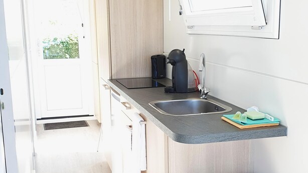 A compact kitchen with a sink, a coffee maker, and a trash bin. - Floating Lodge With Terrace in Lelystad (Lelystad)