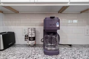 Ett kök med en kaffebryggare, en brödrost och en burk med kaffe.