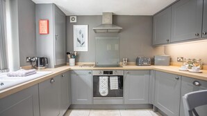 A modern kitchen with grey cabinets, a built-in oven, a toaster, and a coffee maker. - Cosy Stone Cottage In Gargrave Near Skipton (Skipton)