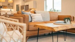 A modern living room with a sofa, a coffee table, and pendant lights. - Park Point Lagom, Heirloom Vacations (Duluth)
