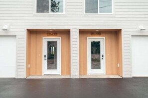 A building with two identical doors, each with a wooden frame and a small window above. - Park Point Scandinavian Home, Heirloom Vacations (Duluth)