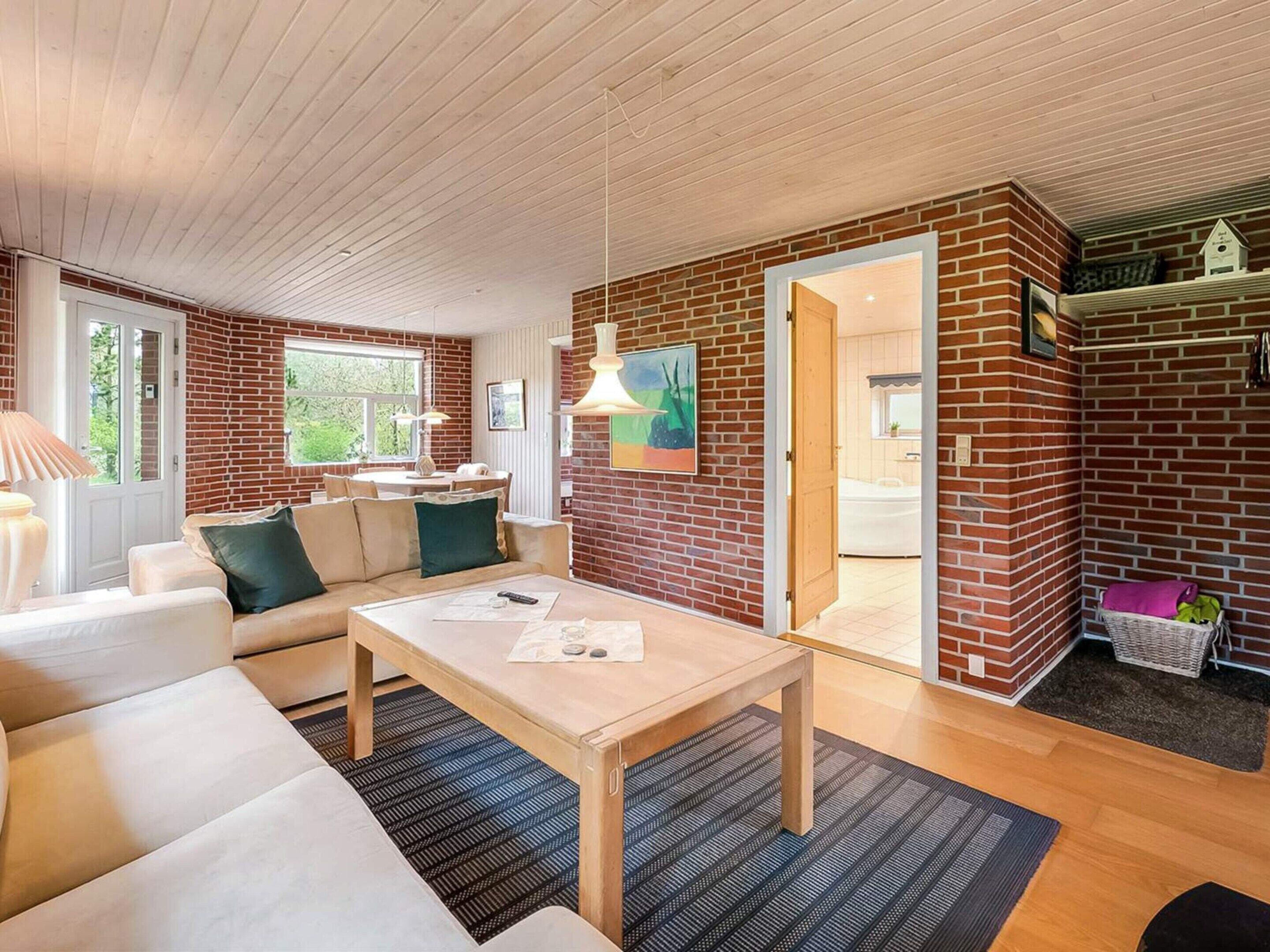 A cozy living room with a sofa, a coffee table, and a dining area with a table and chairs.
