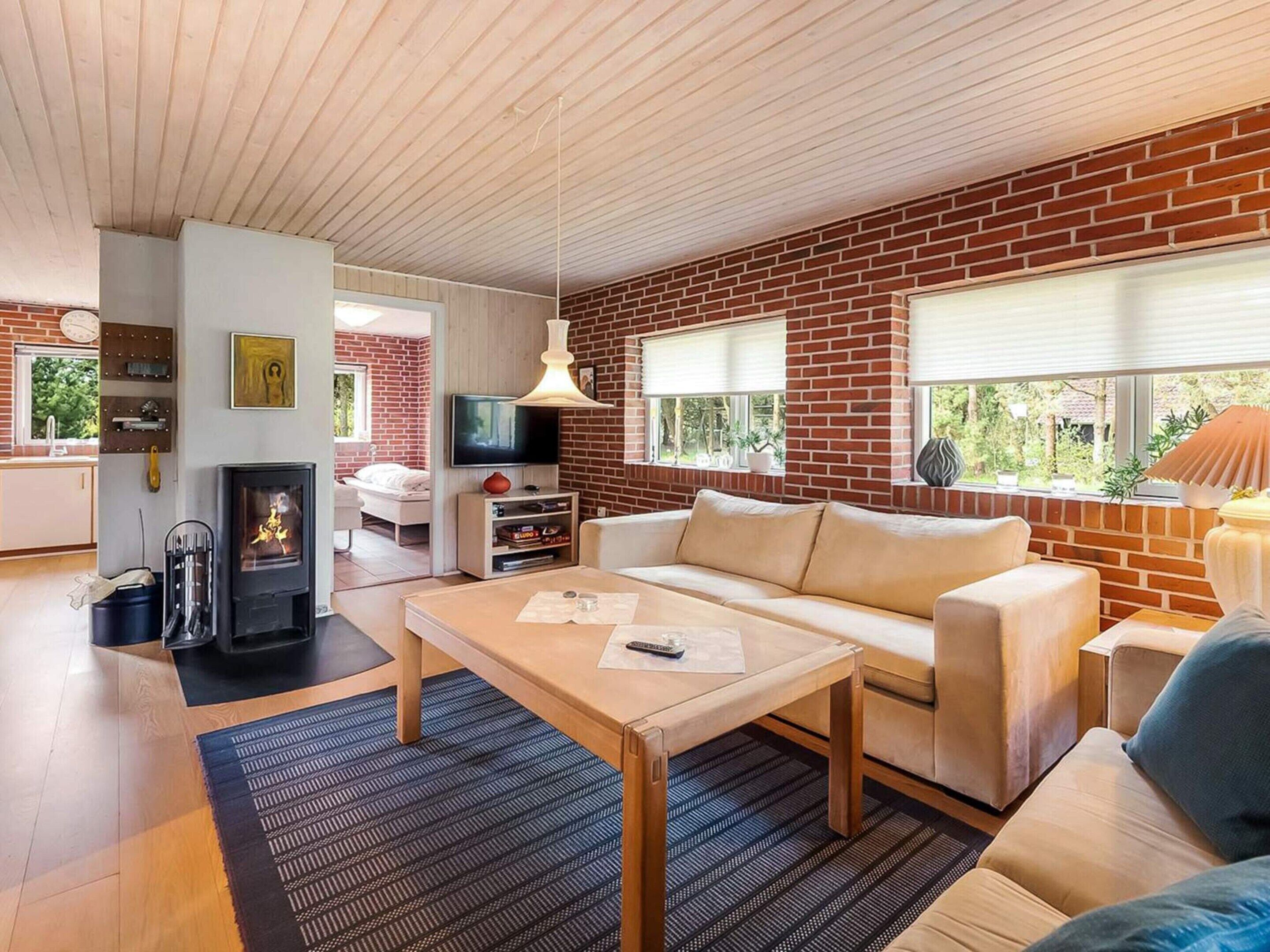 Un salon avec une cheminée, un canapé, une table basse et un téléviseur.