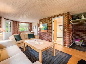 Ein gemütliches Wohnzimmer mit einer Couch, einem Couchtisch und einem Essbereich mit Tisch und Stühlen.