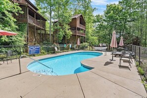 A pool area with lounge chairs and a sign indicating pool rules. - Luxury, Views Near RockyTop, Sauna, Free dollywood (Gatlinburg)