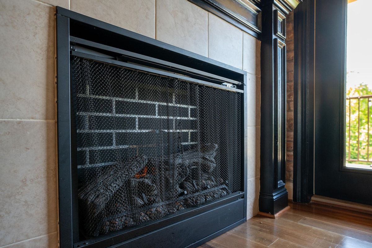 A fireplace with a brick design, a black frame, and a glass screen.