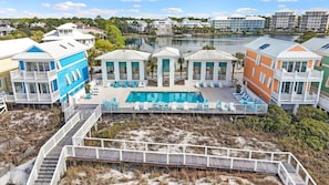 Ein Strandhotel mit Pool, Sitzgelegenheiten im Freien und einer Promenade, die zum Strand führt.