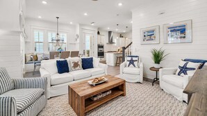 A spacious living room with a white sofa, striped armchair, and a wooden coffee table. - 🦩Book Me Baby! Seaesta in Prominence🦩 (Inlet Beach)