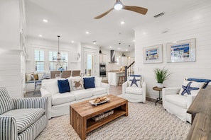 A spacious living room with a white sofa, striped armchair, and a wooden coffee table. - 🦩Book Me Baby! Seaesta in Prominence🦩 (Inlet Beach)