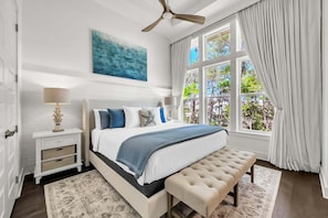 A bedroom with a bed, bedside table, lamp, bench, and a view of trees through a window. - 🦩Book Me Baby! Seaesta in Prominence🦩 (Inlet Beach)