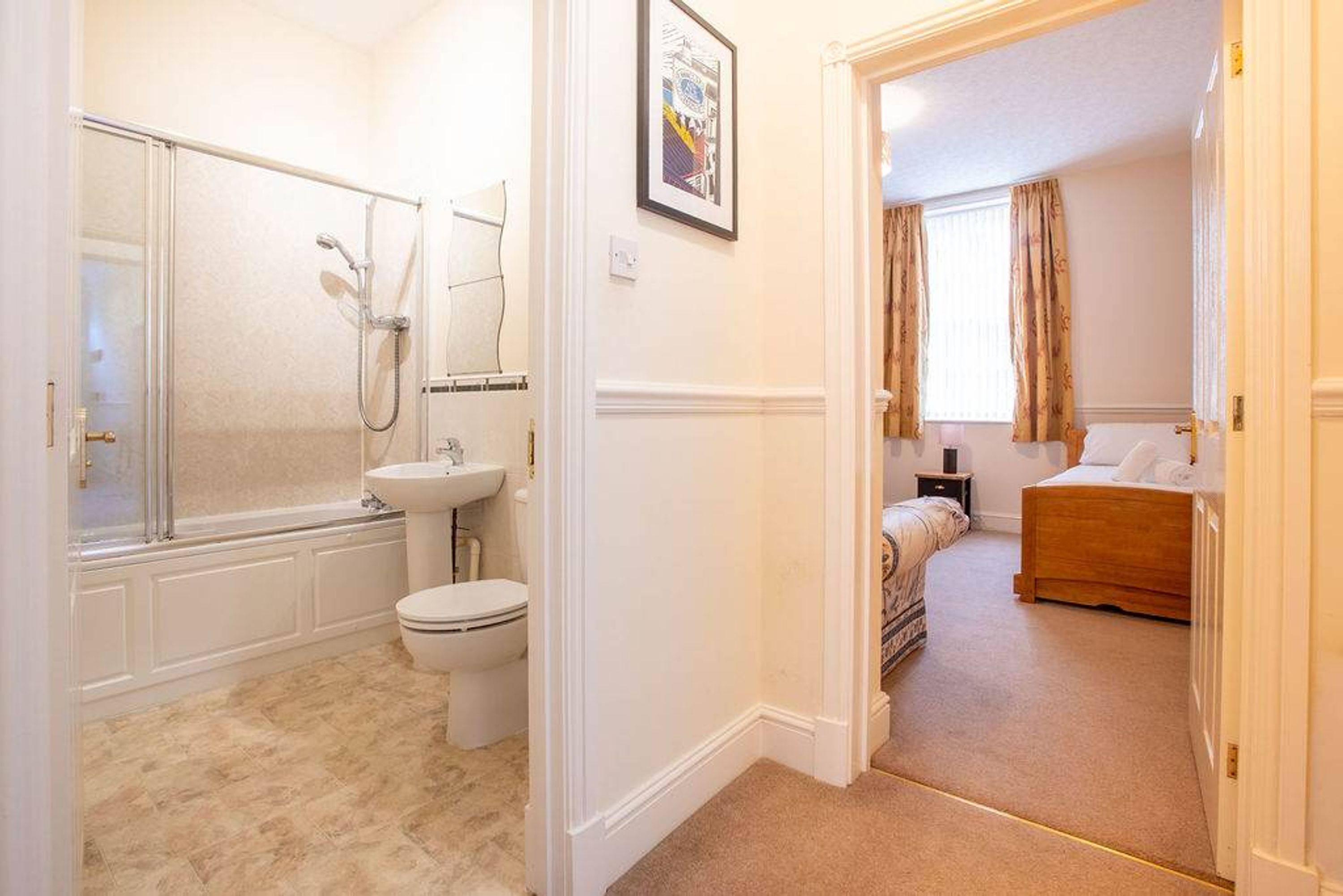 A bathroom with a shower, toilet, and sink.