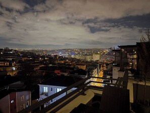 A cityscape at night with buildings and a distant view of a stadium. - Taksim Square-1br Rooftop Suite 07 (Istanbul)