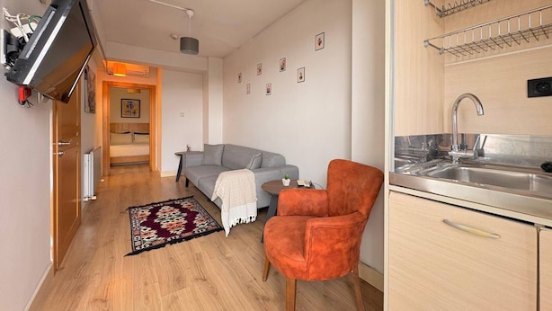 A compact living space with a kitchenette, a sofa, a chair, and a small dining table. - Taksim Square-1br Rooftop Suite 07 (Istanbul)